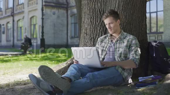 他在社交媒体上聊天在大学公园里欢笑和放松视频的预览图