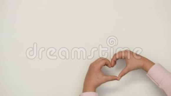 孩子用白色背景的手显示心脏形状家庭气氛充满爱视频的预览图