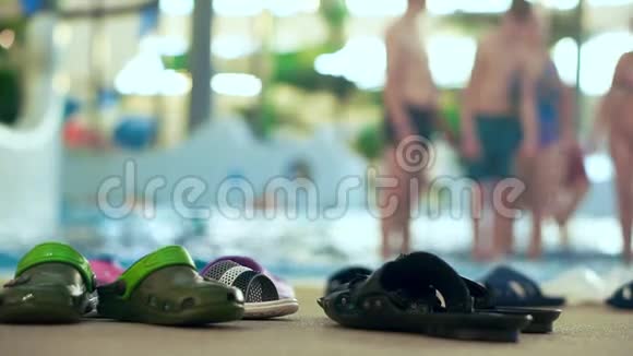 室内水上乐园岸边的许多拖鞋离焦背景视频的预览图