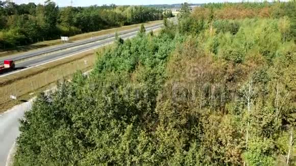 卡车和汽车在森林之间的高速公路上行驶视频的预览图