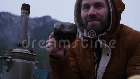 留胡子的人正在山谷的旅游营地喝茶在寒冷的季节旅行作为一种生活方式慢慢慢慢视频的预览图