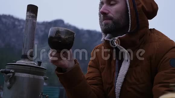 留胡子的人正在山谷的旅游营地喝茶在寒冷的季节旅行作为一种生活方式慢慢慢慢视频的预览图