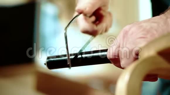 一个男人用锯子锯金属管子的特写镜头视频的预览图