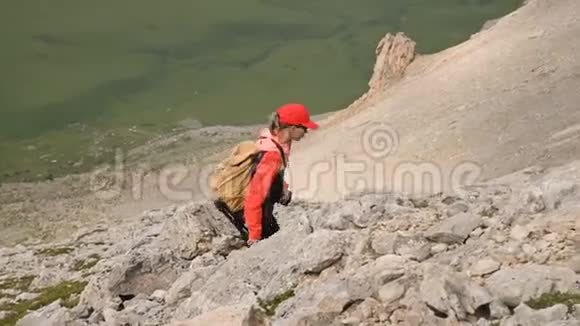 女孩摄影师在高原悬崖和云层的背景下上山概念视频的预览图