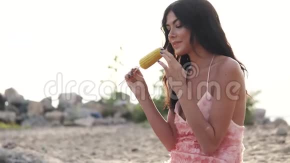 女孩在海滩上吃玉米视频的预览图