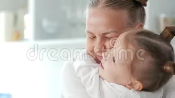 快乐的小女孩在厨房拥抱她的母亲视频的预览图