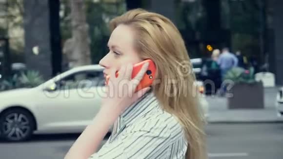 商务女性在市中心散步打电话慢动作4K视频的预览图