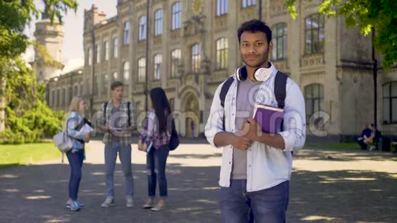 优秀的学生站在他的大学附近真诚地对着镜头微笑视频的预览图