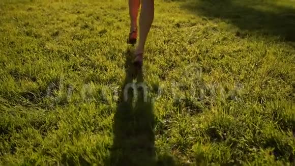 女人的脚在公园的草地上奔跑视频的预览图