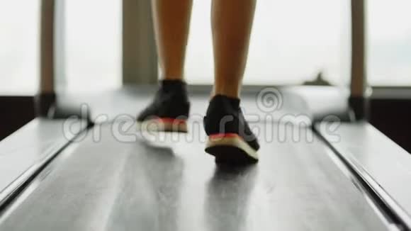 在健身房跑步机上行走的女人腿视频的预览图