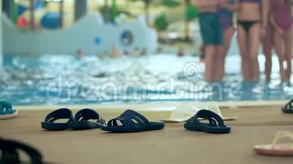 室内水上乐园岸边的许多拖鞋离焦背景视频的预览图