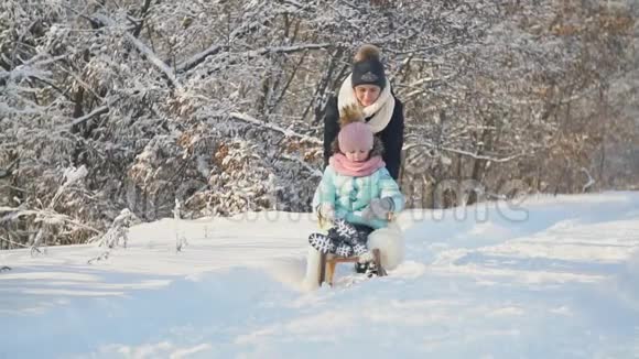妈妈把女儿卷在雪橇上视频的预览图