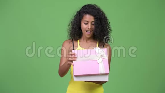 年轻漂亮的西班牙女人在打开礼物盒时显得很惊讶视频的预览图