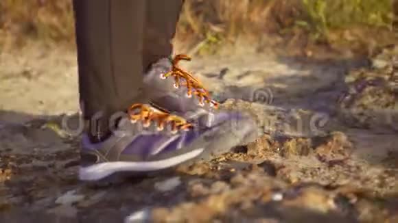 步行者的特写镜头他的靴子踩在一条带石头的山路上视频的预览图