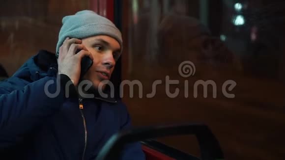 孤独的年轻人坐在电车里晚上打电话视频的预览图
