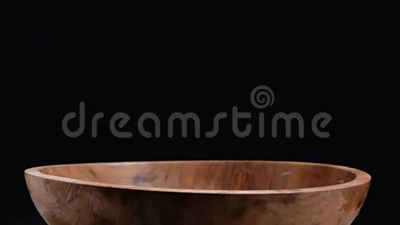 大量五颜六色的蔬菜掉落在木碗里视频的预览图