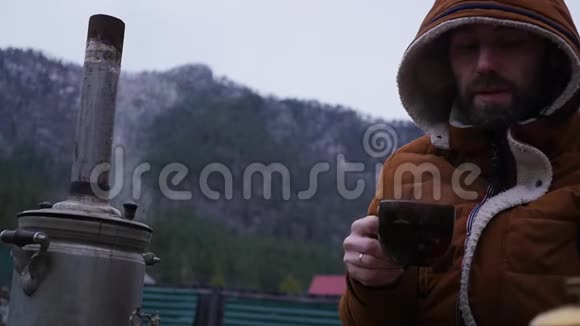 留胡子的人正在山谷的旅游营地喝茶在寒冷的季节旅行作为一种生活方式慢慢慢慢视频的预览图