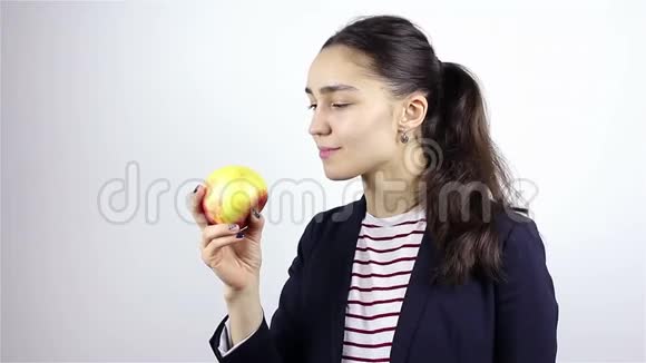 美丽的年轻女子嗅着红苹果视频的预览图