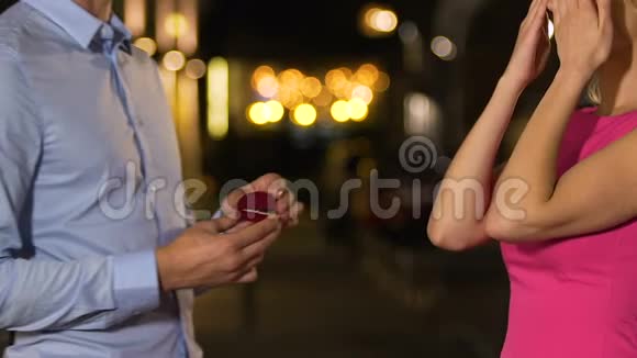 年轻女子用双手捂住眼睛男人用订婚戒指求婚快乐视频的预览图