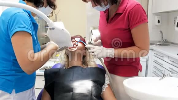 牙科护士协助牙科医生治疗病人牙齿4k镜头视频的预览图