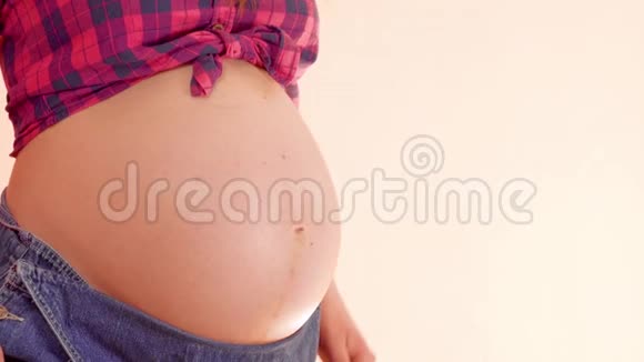 一个怀孕的女人在她赤裸的大肚子上戴着可爱的小手套走路想让妈妈玩视频的预览图