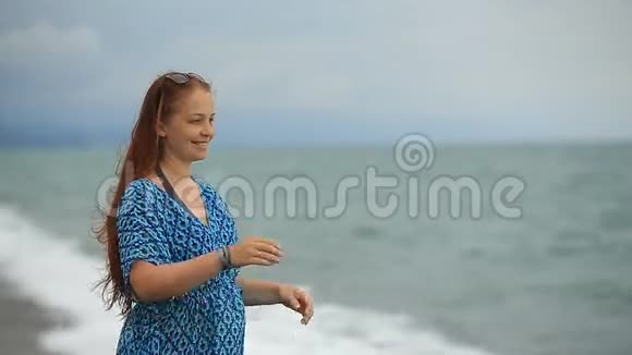 海滩上一个红头发的女人的肖像视频的预览图