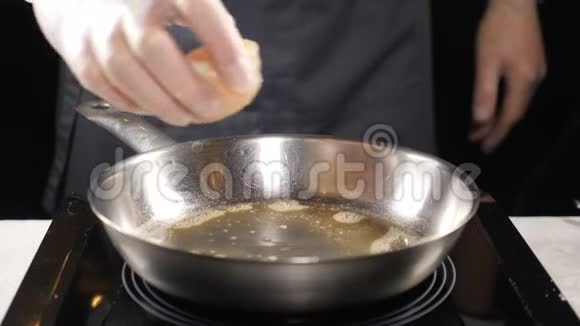 食品艺术在餐馆煮海鲜职业厨师在手套上缓慢地把扇贝放在煎锅上高清高清视频的预览图