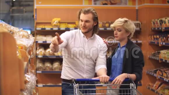 快乐可爱的情侣在超市里选择新鲜面包的画像视频的预览图