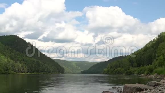 河流上方快速移动的体积云的夏季风景视频的预览图