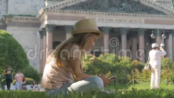少女游客坐在城市街道上度假时用智能手机搜索信息技术休闲视频的预览图