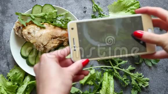 一位年轻女性在智能手机上为社交网络拍照她的食物视频的预览图