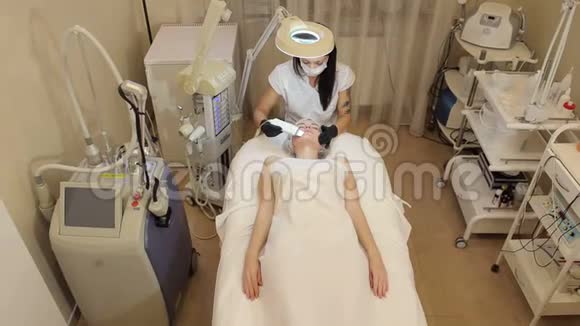 美容师让一个年轻女孩在水疗中心对面部进行超声波清洗视频的预览图