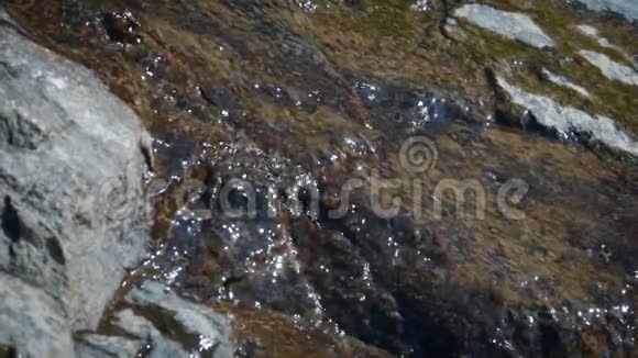 小溪的冰川水流过石头视频的预览图