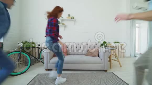年轻的朋友们在沙发上奔跑跳跃然后在家里一起微笑和竖起大拇指视频的预览图