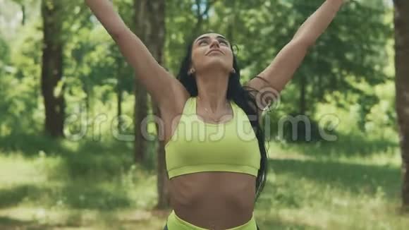 漂亮健康的年轻女孩在户外做热身伸展运动运动健身视频的预览图