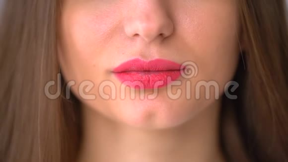 美丽的粉红色丰满的嘴唇特写咬巧克力年轻的女孩视频的预览图