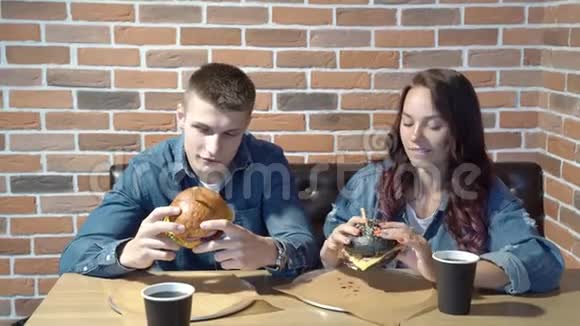可爱的情侣在咖啡馆里聊天吃汉堡包视频的预览图