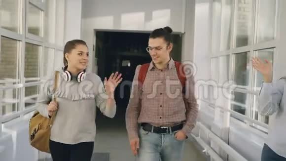 两名男女学生正在大学大厅里讨论一些事情2他们在窗边迎着朋友视频的预览图