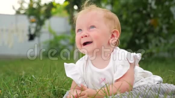 婴儿出牙背景婴儿出牙问题婴儿躺在绿草上在花园里玩耍的孩子牙齿是视频的预览图