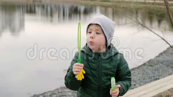 小河边有泡泡的小男孩在户外视频的预览图