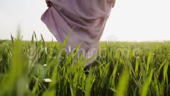 穿着粉色衣服的女人光着脚走在草地上视频的预览图