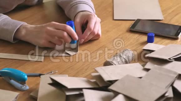 女人用牛皮纸做了一个纸袋用来做日历双手特写把纸粘上视频的预览图