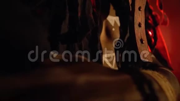 身穿白色图案的非洲黑人萨满戴着面具双手放在胸前站在红色灯光下视频的预览图