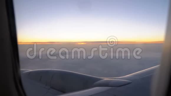 傍晚日落时分一架客机在云中飞行从窗外景色视频的预览图
