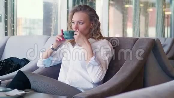 一个女人在咖啡馆喝茶的特写镜头视频的预览图