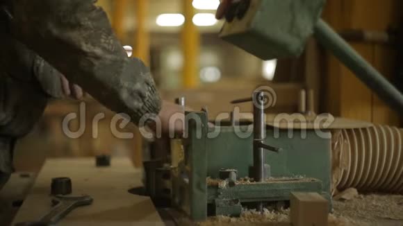 锯木厂的工人在切边机上更换刀具并将机器设置为木材加工特写视频的预览图