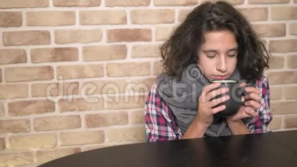 季节性发热的概念生病的少年抱着一杯热饮料一个不快乐的少年一头卷曲的黑发视频的预览图
