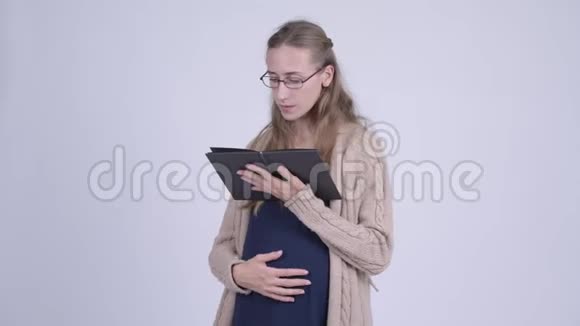 年轻孕妇带眼镜看书视频的预览图