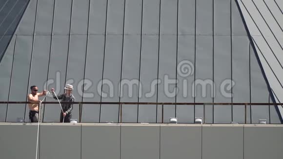 2大楼顶上有两个人准备好休闲裤视频的预览图
