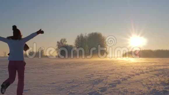 冬天的女人在白雪皑皑的阳光下奔跑手臂挺直视频的预览图
